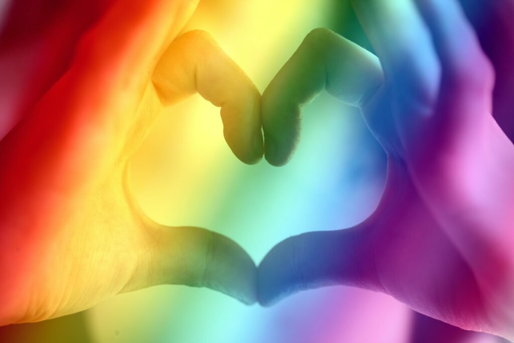 pexels-photo-3802075-3802075 Hands forming a rainbow heart shape, symbolizing love, unity, and LGBTQ pride.