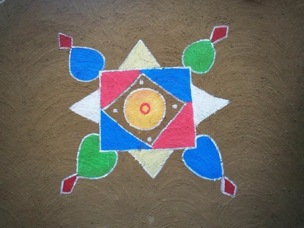 pexels-photo-191077-191077 Vibrant geometric rangoli design on brown textured surface, showcasing Indian folk art and cultural heritage.