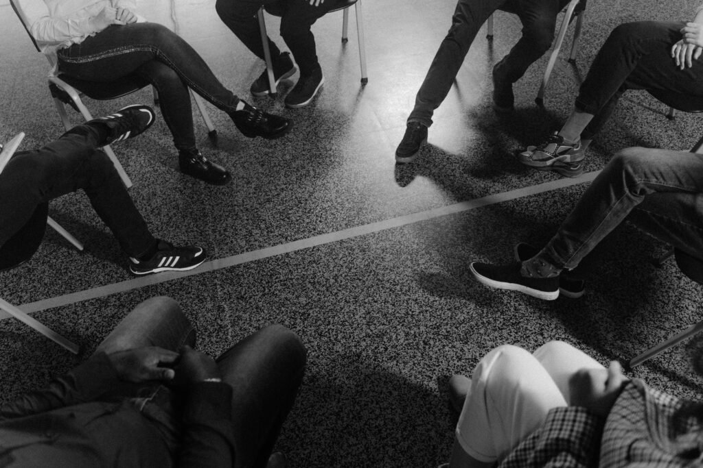 pexels-photo-5711382-5711382 Black and white photo of a support group session indoors with diverse participants.